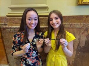 COYAC members Taleen Sample and Aimee Resnick hold pens from Gov Polis bill signing at Capitol HB22-1052 Promoting Crisis Services To Students June 8, 2022