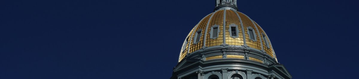 Gold dome of the Colorado State Capitol Building against a blue sky
